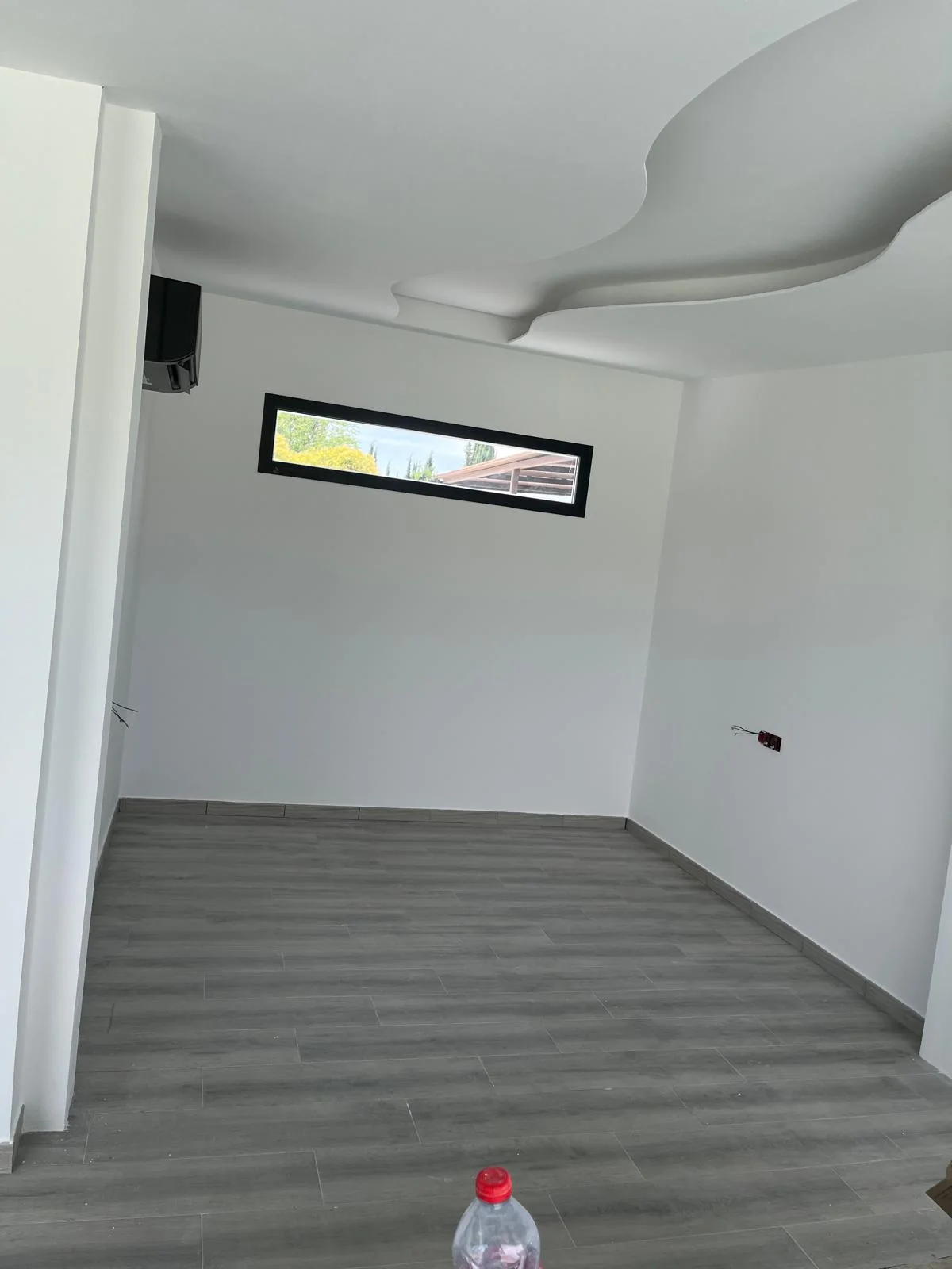 Estancia reformada con suelo gris y techo decorativo